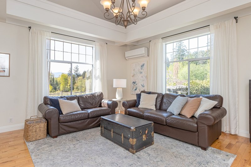 Bright farmhouse living room with large windows overlooking the Emandare estate