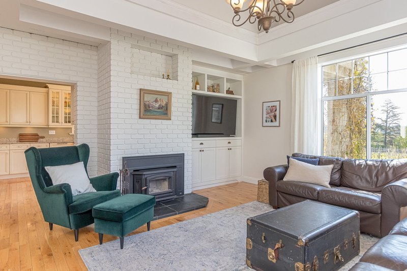 Living room with a white brick fireplace in the renovated farmhouse at Emandare Winery